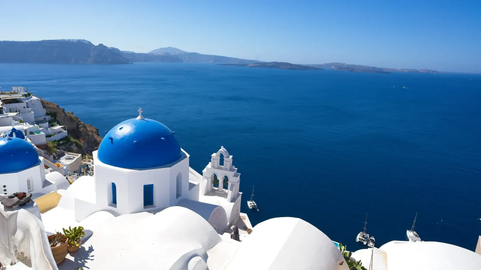 Santorini Views by Mr. Wanderer White-washed buildings with blue domes overlooking the blue ocean