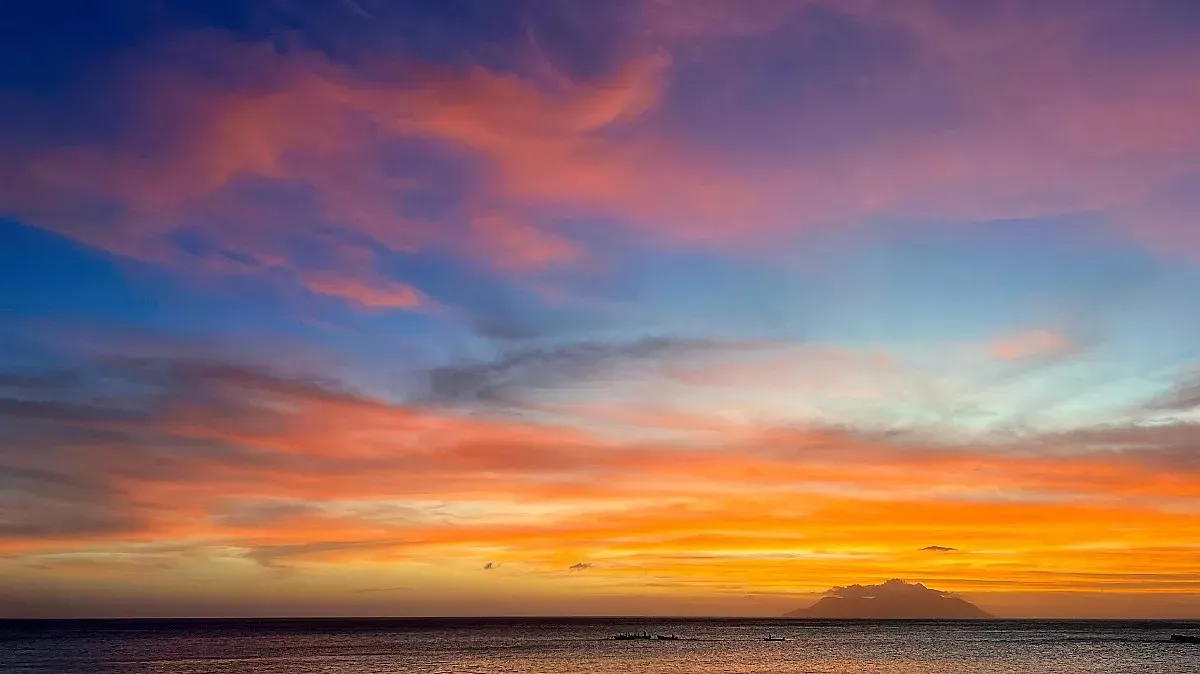 Seychelles Sunset by Mr. Wanderer Pink, blue, orange, and yellow sunset over a narrow strip of water