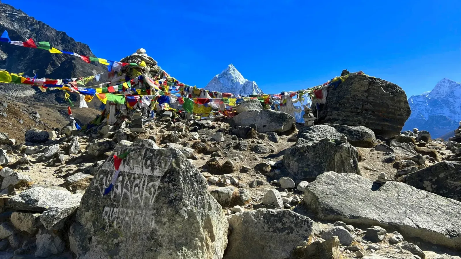 EBC Trek Memoria by Mr. Wanderer Carved rocks with prayer flags strung between them